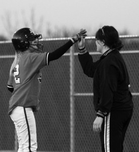 Coach Lindsay Kincaid gives player Loryn Goebel a highfive.