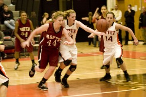 Sophomores Katie Biggers and Jessica Johnson dive after the basketball at their game verses SM North on Dec 10 at SM Northwest. NW won the game with the score of 44 to 38.