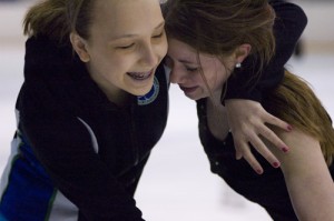 Freshman Elizabeth Hudson hugs senior Meghan Barnes as Hudson shows up for practice. 