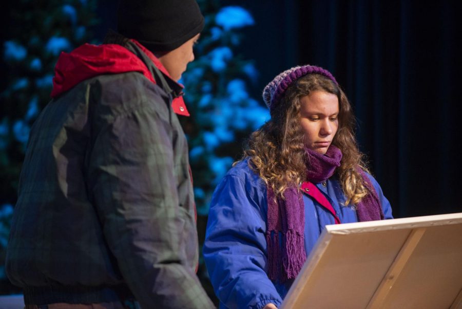 Under their 12 layers of winter clothes and the hot stage lights, junior Natalie Hole and senior Christian Anderson examine a painting during a dress rehearsal of Almost, Maine on Sept. 24.
