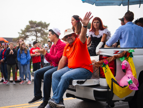 On the back of the office truck, Athletic Director Angelo Giacalone waves the students lining 67th street Oct 5. 