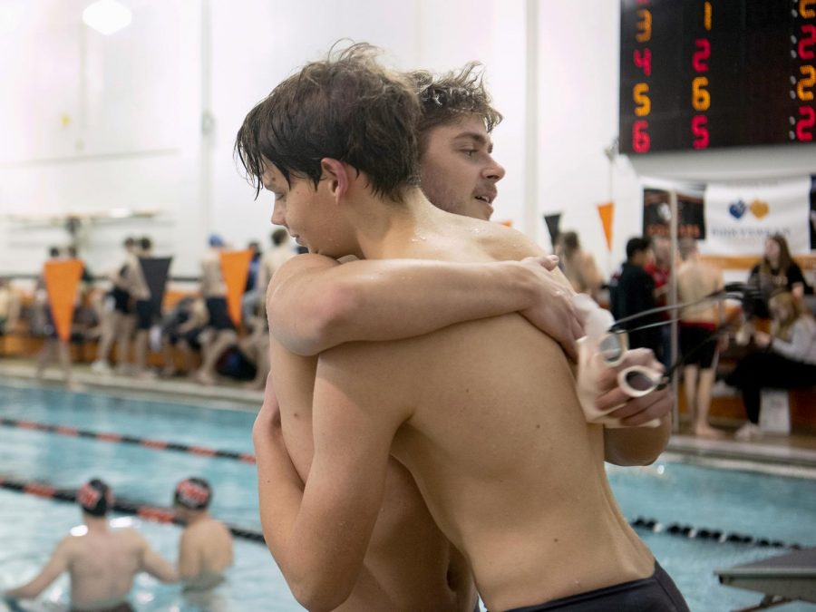 Behind the blocks, sophomore Alex Savinkov hugs senior Scott Klein Jan. 13 at the NW Pool. Savinkov and Klein both qualified for state in the 50 and 100 yard freestyle. “My favorite thing about swim is the brotherhood that has grown over the years,” Savinkov said. “Everyone is just as passionate about your success as their own.”