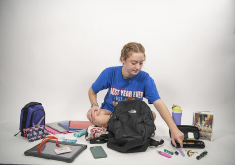 Freshman Halle Grey sits in room 151 with the contents of her backpack in front of her. 