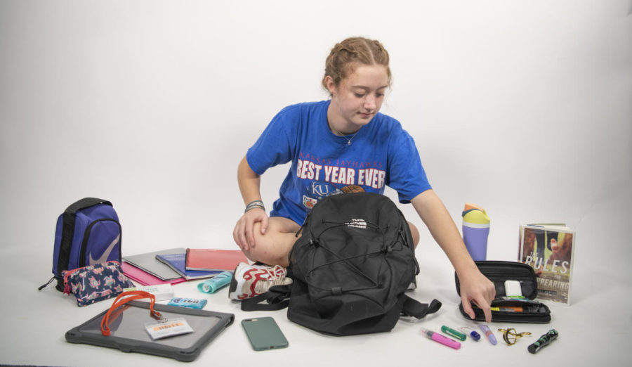 Freshman Halle Grey sits in room 151 with the contents of her backpack in front of her. 