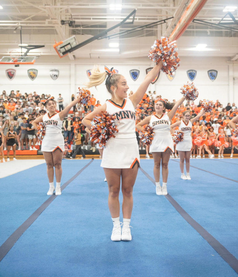 With her pom-pom raised, sophomore Taytum Hollingsworth cheers Aug. 31 in the Main Gym. JV cheer was performing their routine for Bonfire. “I thought the routine went very well, especially the stunts,” Hollingsworth said.