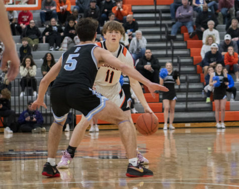 Dribbling, sophomore Van Collins looks for a pass Jan. 13 in the Main Gym. With a score of 57-55 the Cougars beat the Lancers for the third year in a row. “We knew that it was going to be a hard game, so we came out with a lot of energy and were locked in on getting the win,” Collins said.