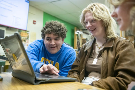Juniors Tad Lambert and Lily Reiff watch swim footage Jan. 19 in Room 153. Lambert and Reiff were editing their swim recap for Cougar Roundup. “[KUGR] is such a great environment for creativity but also to form amazing friends,” Lambert said. “KUGR has become like a home for me and I feel like I’ve gotten super close with so many other members.”
