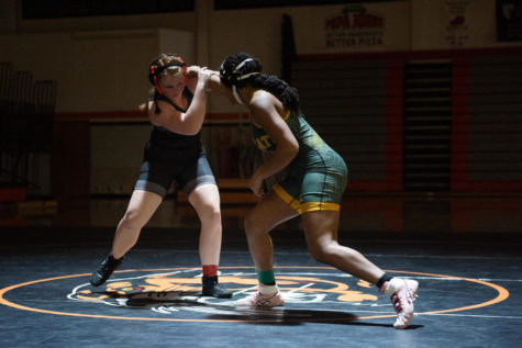 Holding her opponents arm, junior Hannah Mott wrestles Dec. 7 in the Main Gym. Mott won 2-0 with two pins. “Strategies I typically use against my opponents are being as calm as possible in the toughest situations,” Mott said. “I focus on being as patient as possible without getting overwhelmed.”