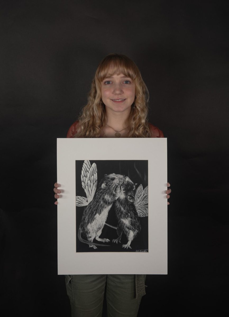 Senior Teal Franklin holds up her art piece ‘Fairy Rats’ Feb.8 in Room 151. Franklin used scratch board and stencil to make the piece.
Haylee Bell