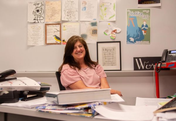 Smiling, english teacher Kathy Stewart sits at her desk April 25 in Room 131. Stewart has been teaching at NW for 18 years and plans on going to Hawaii for her first retirement trip. photo by Andie Berg
